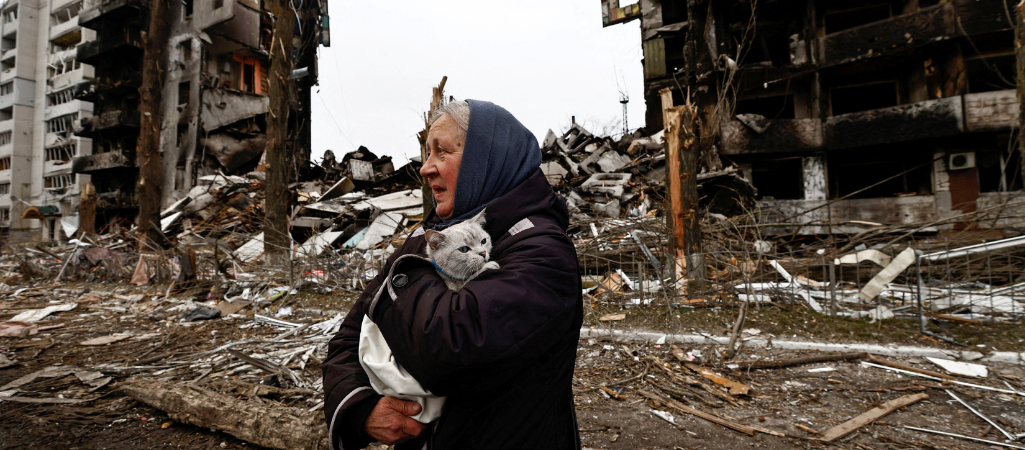 Kobieta z kotem wśród zniszczeń spowodowanych rosyjskim atakiem rakietowym, Borodianka, Ukraina, 5 kwietnia 2022 r. fot. Zeohra Bensemra / Reuters / Forum